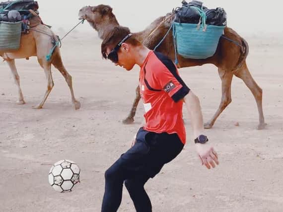 John juggles a football across the desert