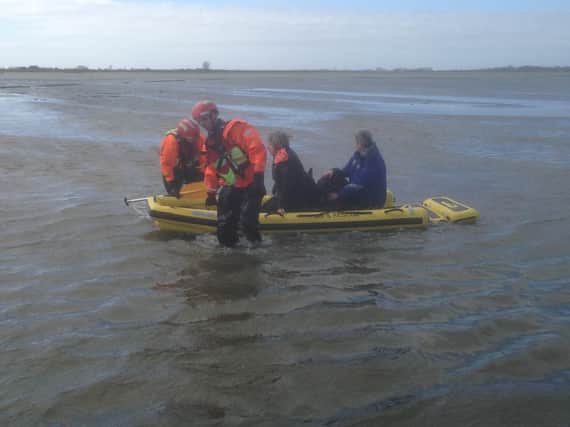 Firefighters soon arrived and launched a water rescue mission using an inflatable sledge to reach the women. Pic - Chris Kelly and Peter Kenworthy