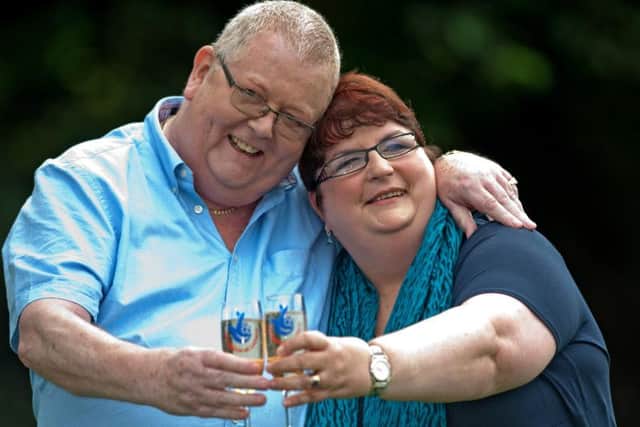 Colin Weir (L) and his wife Chris pose for pictures with champagne during a photocall in Falkirk, Scotland, on July 15, 2011 (Wattie Cheung/AFP/Getty Images)