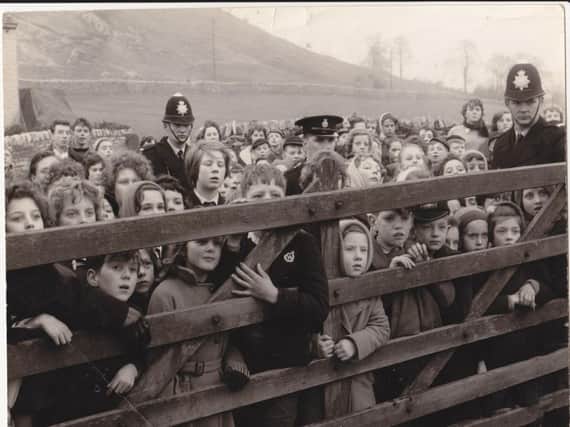 Children in a scene from Whistle Down The Wond jostling in silence to get a glimpse of 'the man'
