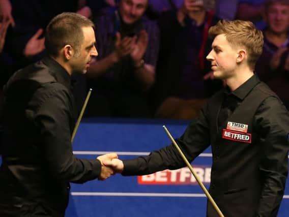 James Cahill, right, shakes hands with Ronnie O'Sullivan after beating the five-time world champion