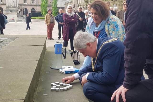 Preston Mayor Trevor Hart lights a candle at the vigil.