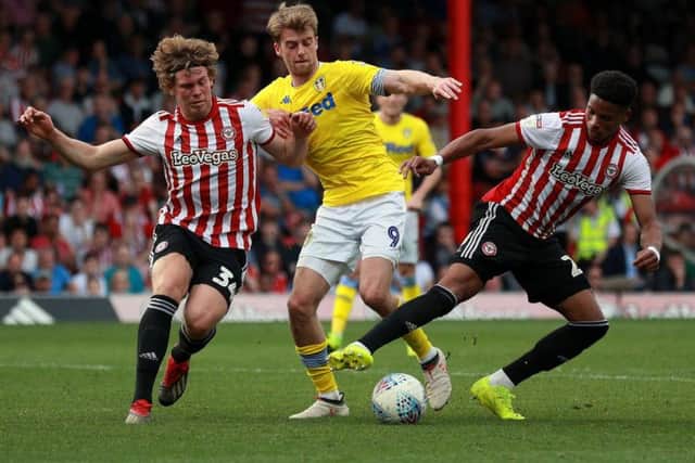 Leeds United's Patrick Bamford battles for the ball with Brentford's Mads Bech Sorensen (left) and Julian Jeanvier (right) during the Sky Bet Championship match at Griffin park, Brentford.
