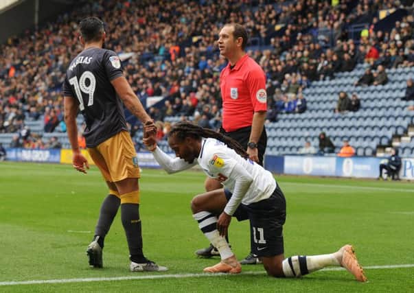 Daniel Johnson is helped to his feet by Sheffield Wednesday's Marco Matias