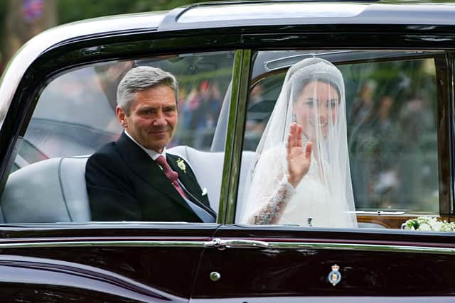 Kate Middleton waves as she travels in a Rolls Royce Phantom VI, accompanied by her father Michael Middleton