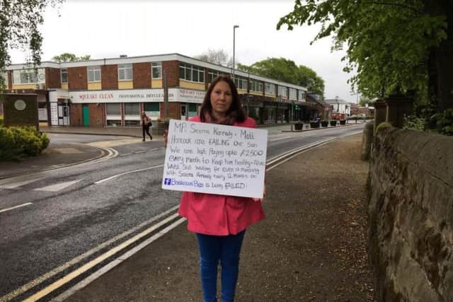 Joanne Griffiths claims the Tory Government has let down her son Ben. She is protesting on polling day, with Seema Kennedy's office in the background.