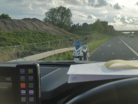 The moped facing the wrong way on the M55 after it had been stopped by police. Pic: @Lancsroadpolice