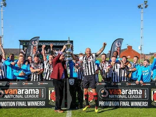 Ken Wright lifts the trophy with captain Andrew Teague