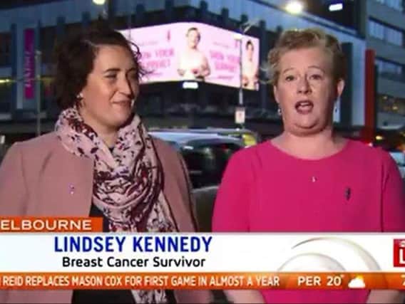 Lindsey Kennedy (right) is interviewed live on Australian TV in front of her Pink Bun photograph on a giant  billboard  in Melbourne city centre.