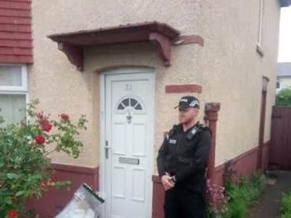 A police officer stands outside the property on Raven Street, Deepdale.