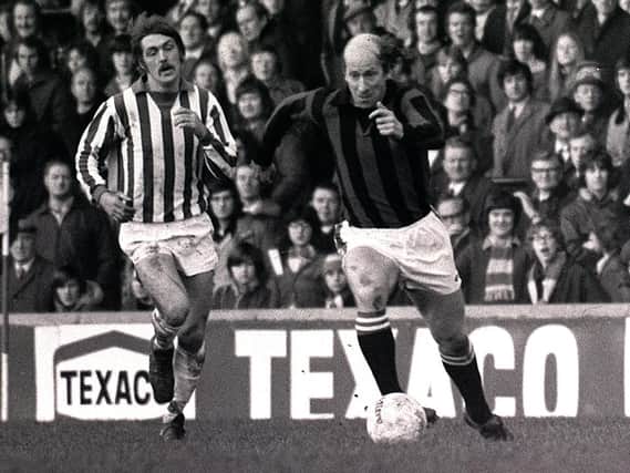 Bobby Charlton dons a red and black away kit while playing for Preston North End in the 1970s