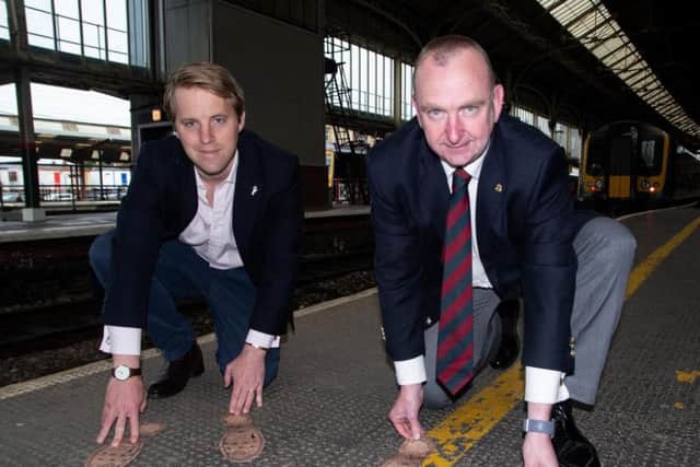Rowley Greg, CEO of Remembered / There But Not There and County Councillor Alf Clempson with the bootprints at Preston Train Station. Photo: Kelvin Stuttard