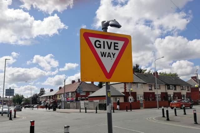 'Give way' signs at the Harewood Road exit from the estate have bright backgrounds and are lit at night...