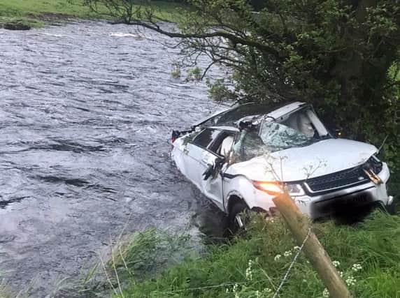 A motorist was taken to hospital with back injuries after the Land Rover Evoque she was driving plunged into the river.