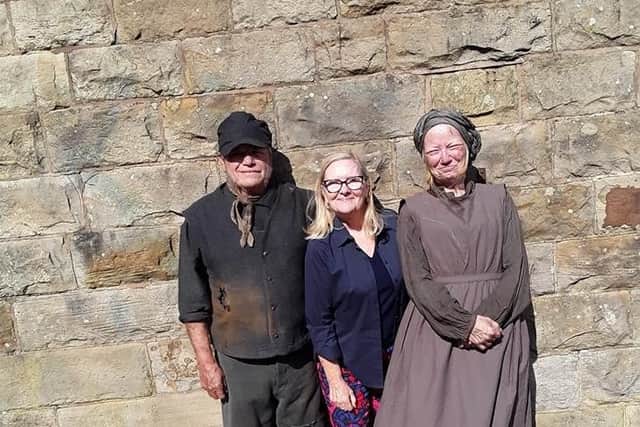 Burnley resident Evelyn Grimshaw poses with two of the actors on the set of A Christmas Carol which is being filmed at Queen Street Mill.