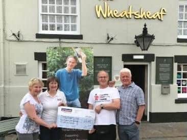 Mike Coleran presents a cheque for 4,864 for Cardiac Risk in the Young (CRY) after cycling 900 miles from the Isle of Wight to Inverness