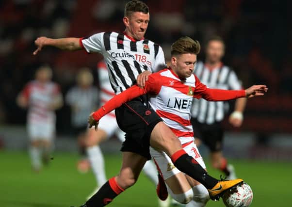 Scott Leather, left, challenges on Alfie May of Doncaster Rovers during a FA Cup 1st Round replay.