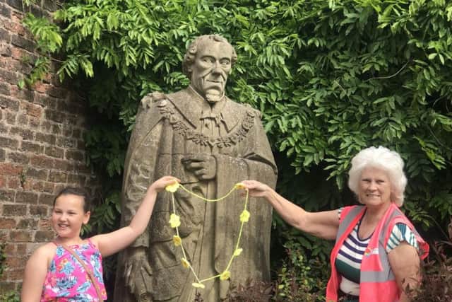 A young crafter who made the primrose necklace for the Disraeli statue is  pictured with Iris Smith, chair and founder of Chorley in Bloom