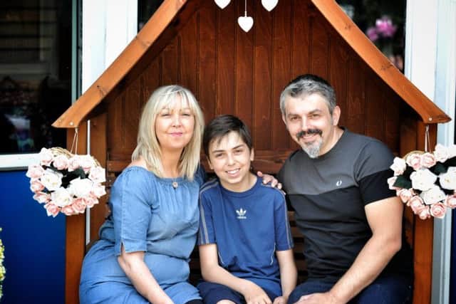 Lisa and Andrew Roussos sit in Saffie's garden with their son Xander
