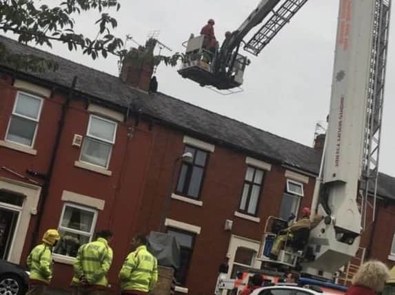 A cherry-picker was used to help get the man down safely.