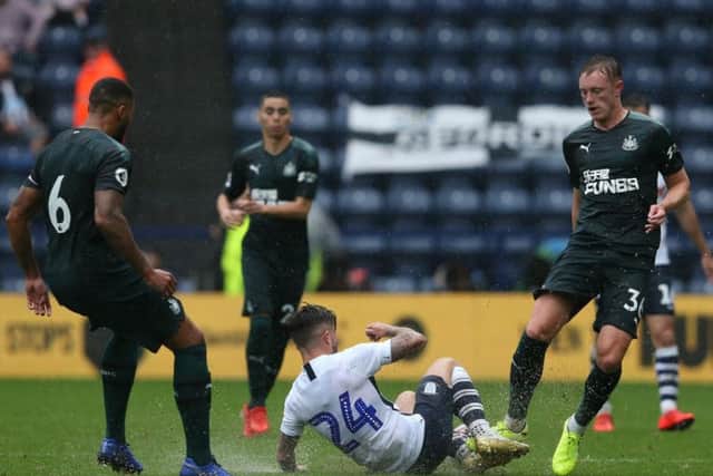 PNE striker Sean Maguire splashes through a challenge with Newcastle's Paul Dummett