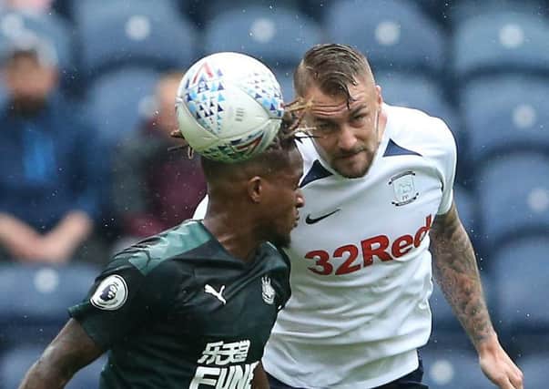 Preston centre-half Patrick Bauer heads clear under pressure from Newcastle's Rolando Aarons