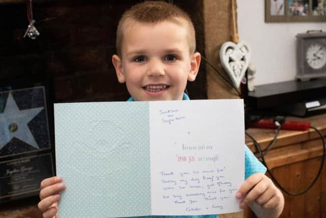 'Superhero' Jaxon proudly holds his 'thank you' card from a grateful Colette Martin
