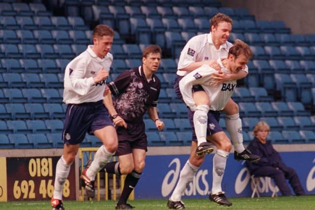 Julian Darby gives Paul McKenna a piggyback after scoring at Millwall