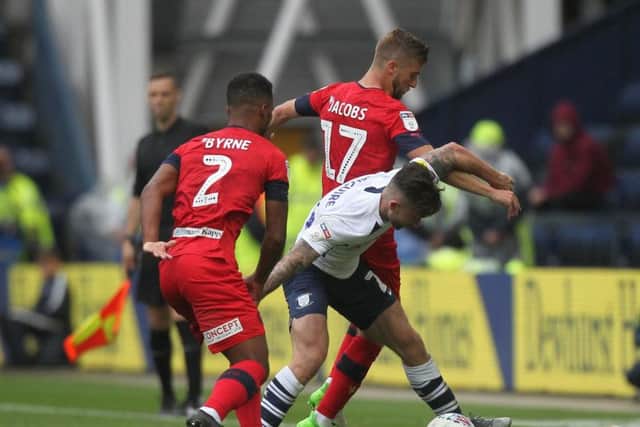 Preston's Sean Maguire battles with Wigan's Nathan Byrne and Michael Jacobs