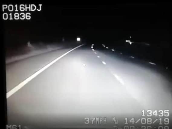 Police footage shows a man running down the hard shoulder of the M61 near Chorley at 12.30am this morning (August 14). Can you spot him? Credit: Lancs Road Police