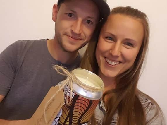 Katie with boyfriend Ryan and one of her candles made from one of Ryan's beer cans