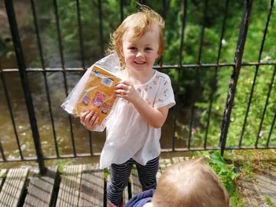 Happy four-year-old Harriet Ormerod proudly shows off a book she found in Haslam Park
