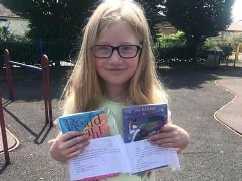 Julie Brogden's daughter Freya, 8, with books ready to be hidden in a top secret location somewhere in Preston