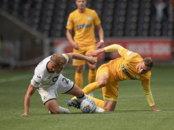 Preston striker Louis Moult tussles for possession with Swansea's Jake Bidwell