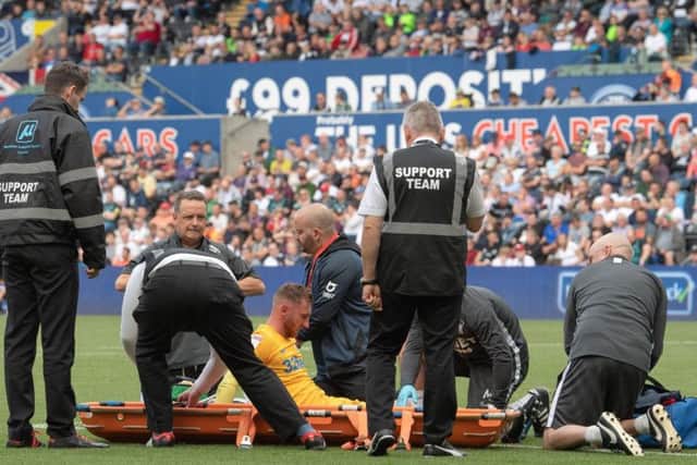 Preston striker Louis Moult is put on a stretcher at the Liberty Stadium after injuring his knee
