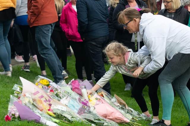 Hundreds of families laid flowers, cards and candles to the sound of a choir singing 'Amazing Grace'