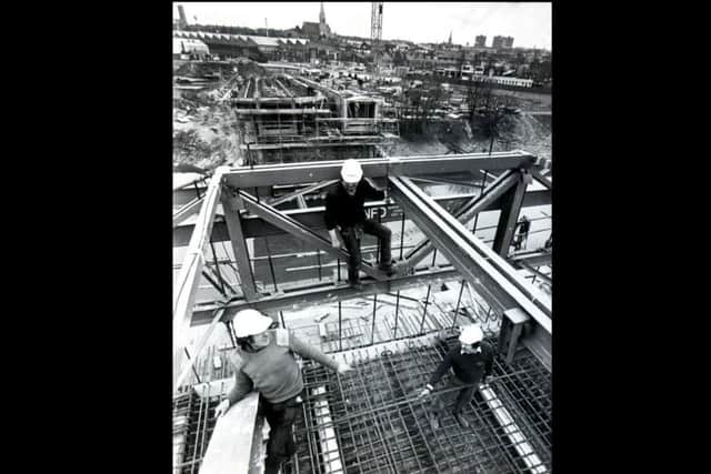 Workmen high up on the projection on the eastern side of the bridge
