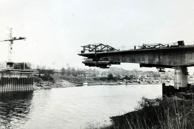 Extending in sections, the bridge reaches out over the river