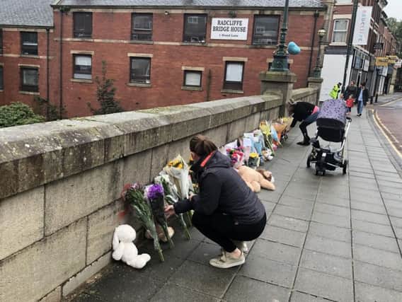 Floral tributes are left on a bridge in Radcliffe, Greater Manchester following the death of a baby boy
