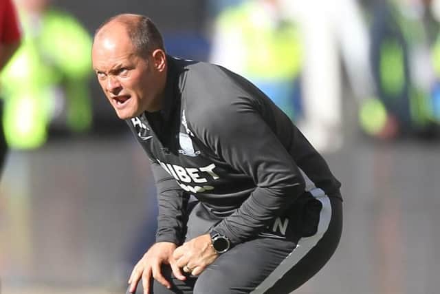 PNE manager Alex Neil crouches down for a better view of the action at Deepdale