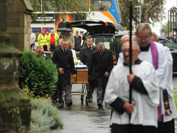 The coffin is led into the church