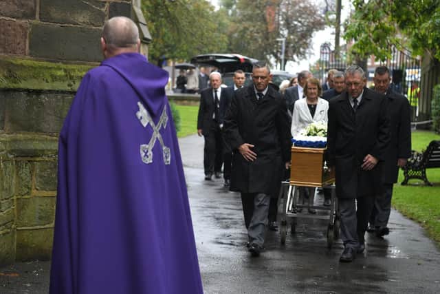 The coffin is led into the church