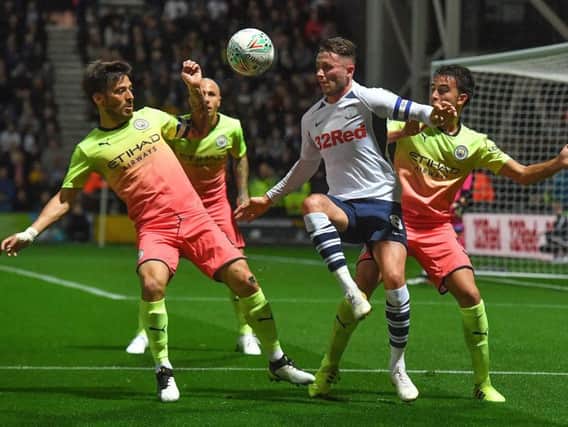 Preston midfielder Alan Browne battles for possession against Manchester City
