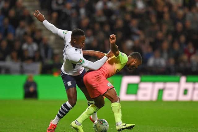Preston right-back Darnell Fisher battles with Raheem Sterling
