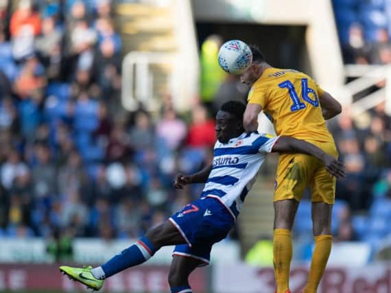 Preston left-back Andrew Hughes competes in the air with Andy Yiadom