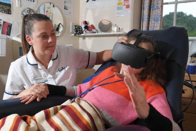 Physio Sinead Gallery helps Cuerden Hall resident Heather Barker try out a virtual reality headset. Photo by Neil Cross