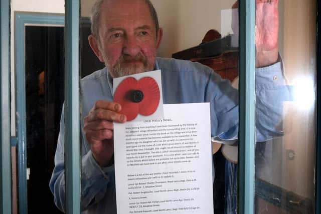 Cen Jaynes with a giant poppy displayed in his window
