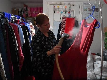 Volunteer Christine Bell steaming a dress for sale at the Longridge RSPCA shop.