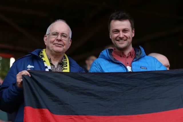 Two smiling Preston fans in the away end at The Valley