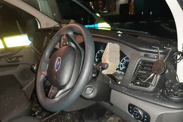 The brick lodged in the dashboard of the police van